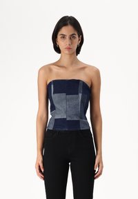 Top din denim fără bretele, cu un design patchwork în nuanțe de albastru închis și deschis, cu cusături structurale și o siluetă ajustată.