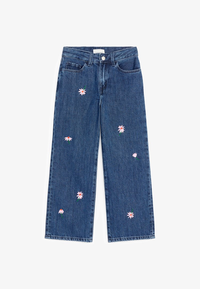 Jean en denim bleu avec jambes larges et petites broderies de marguerites roses dispersées sur les côtés avant.