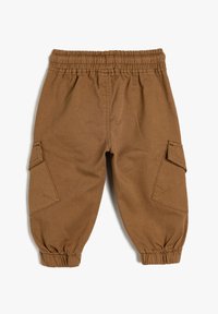 Pantalones cargo marrones con una cinturilla elástica, puños en los tobillos fruncidos y dos bolsillos laterales. Fabricados con un tejido resistente y texturizado.
