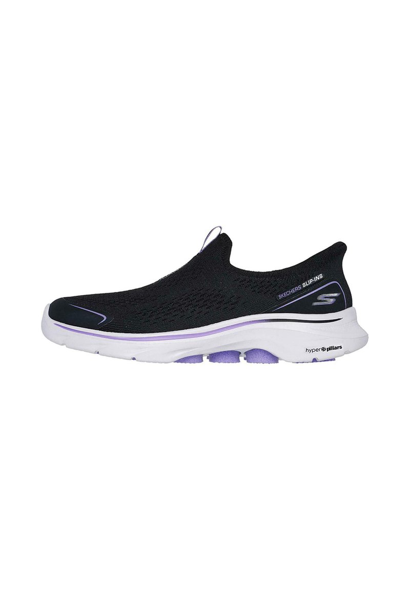 Zapatilla sin cordones negra con parte superior de punto texturizado, suela blanca y acentos morados, que incluye un tirador en el talón para facilitar su uso.