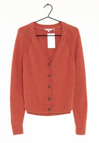Rust-colored knitted cardigan with long sleeves, button front, and ribbed cuffs and hem, hanging on black hanger with white tag.
