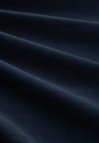 Țesătură de un albastru închis, cu o textură netedă, având pliuri moi și curgătoare și un luciu subtil, ideală pentru îmbrăcăminte sau tapițerie.