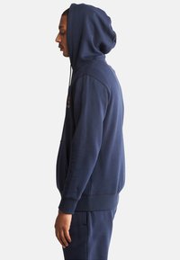 Hoodie bleu marine en mélange de coton, avec une poche frontale, une capuche à cordon et des poignets et ourlet côtelés. Texture simple et douce.