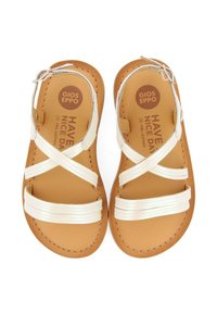Sandali bianchi in pelle con cinturini incrociati, soletta in pelle color cuoio e un logo circolare. Presentano cinturini leggermente texturizzati e dettagli di cucitura.