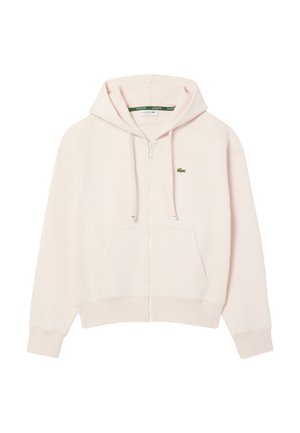 Ljusrosa zip-up hoodie i mjukt tyg, med en framficka och en grön Lacoste-logotyp på bröstet. Justerbar dragsko på huvan.