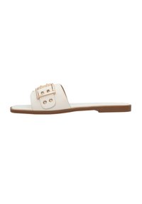 Infradito bianchi con una fascia larga, caratterizzate da una fibbia in oro e dettagli in stud decorativi, su una suola in tessuto marrone chiaro.