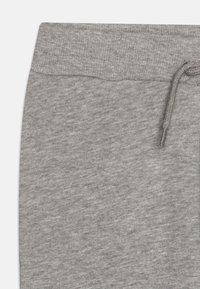 Grå joggebukser laget av et mykt og teksturert stoff, med elastisk linning og snøring for justerbar passform.