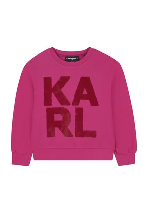 Jasnoróżowa bluza z długim rękawem z dużymi, fakturowanymi czerwonymi literami tworzącymi napis „KARL” z przodu oraz okrągłym dekoltem.