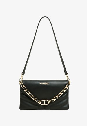 Zwarte leren handtas met een gouden kettingriem, voorzien van een klepsluiting, geperst logo en een diagonale geplooide ontwerp aan de voorkant.