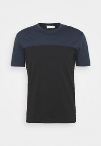 Camiseta de manga corta con la parte superior en azul marino y la sección inferior en negro. Hecha de algodón, presenta un cuello redondo y un logo sutil en el pecho.