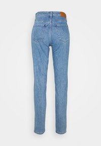Ljust blå denimjeans med rak benklipp, höga midja, två bakfickor och en brun läderlogga på midjebandet.