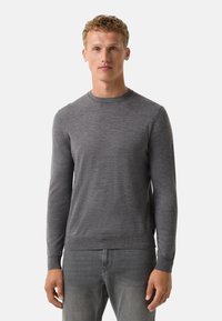 Grauer Langarmpullover mit Rundhalsausschnitt, aus weichem Stoff gefertigt. Besitzt gerippte Bündchen und Saum sowie eine glatte Oberflächenstruktur.
