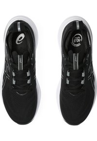 Chaussures de sport noires avec une tige en mesh respirant, des accents réfléchissants et une semelle blanche rembourrée. Elles disposent d'un système de fermeture à lacets traditionnel.