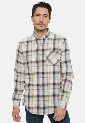 Chemise en flanelle à boutons avec un motif à carreaux multicolores en nuances de blanc, gris, noir et orange, avec une poche poitrine.