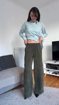 Olive green corduroy wide-leg pants with a drawstring waist, paired with a light blue button-up shirt featuring small textured dots.
