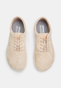 Beige nubukist kingad lukkudega, ümmargune varvas, detailne õmblus ja kontrastne pruuni värvi logopatch. Ortholite sisetallad on kaasas.