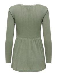 Long-sleeve, light green top with a ribbed texture. Features a scalloped neckline and a flared hemline, made from soft, stretchy material.