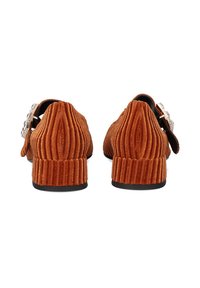 Zapatos de corduroy marrón de tacón bajo con textura acanalada vertical. Presentan una hebilla decorativa metálica en el lateral y una punta redondeada.