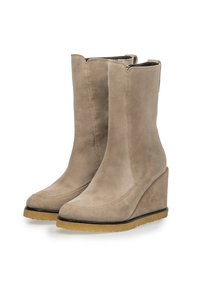 Botines de tobillo de ante beige con cuña, de textura suave, punta redondeada y cierre de cremallera. Forro suave y suela de goma contrastante.