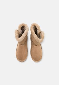 Bottines en suède beige avec une doublure douce et moelleuse. Les bottines présentent un bout rond et une semelle durable avec des coutures visibles.