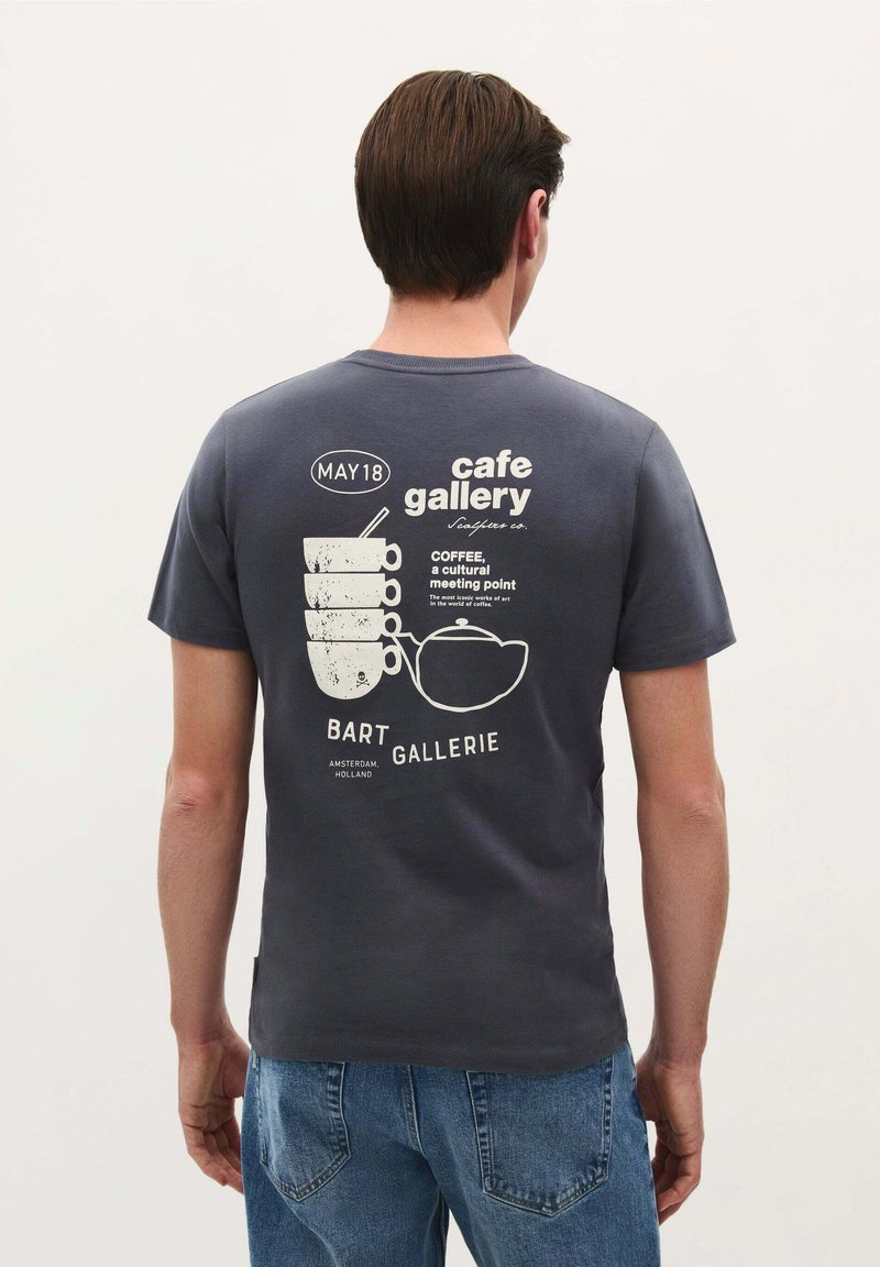 Tricou gri din bumbac, cu un print grafic alb care prezintă cești de cafea și un ceainic pe spate. Guler rotund, cu mâneci scurte.