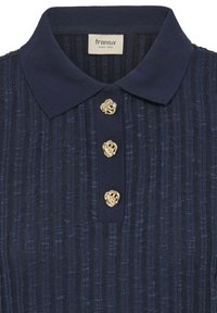 Tumši zils polo krekls ar ribotu faktūru, ar smailu apkakli un trim zelta pogām ar dekoratīvu dizainu. Iekšpusē redzama etiķete.