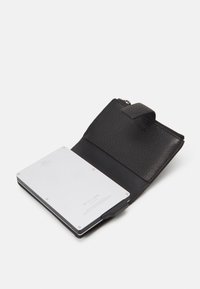 Portefeuille en cuir noir avec une finition texturée, doté d'un porte-cartes en argent à l'intérieur. Le portefeuille possède une fermeture éclair et une lanière en cuir.