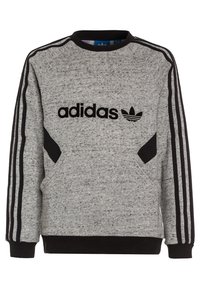 Šedá mikina s černými akcenty. Obsahuje logo Adidas, tři černé pruhy na každém rukávu a strukturovaný design látky.