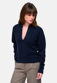 Marineblauer Pullover mit tiefem V-Ausschnitt, gerippten Bündchen und Saum. Hergestellt aus weichem Material, mit einem Kragen-Design und einer lässigen Passform.