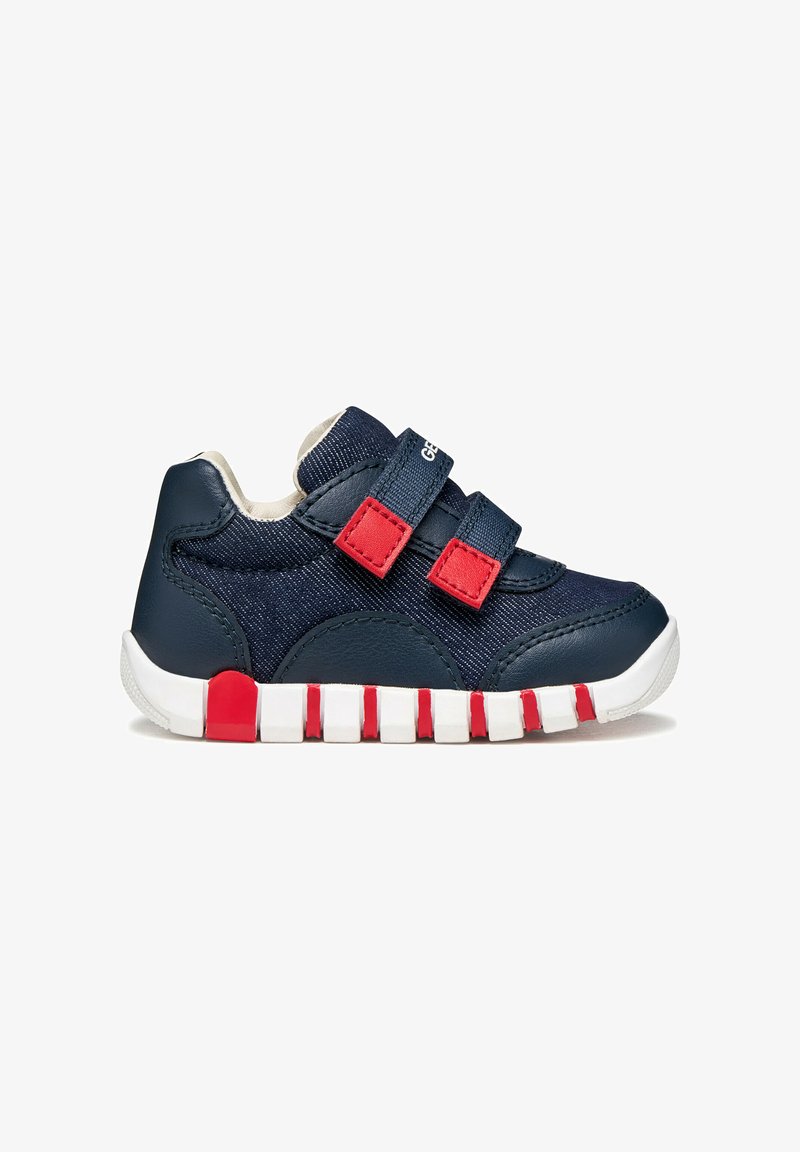 Baskets bleu marine avec des accents rouges, dotées de deux sangles Velcro réglables, d'une tige en tissu texturé et d'une semelle en caoutchouc blanche avec des détails rouges.
