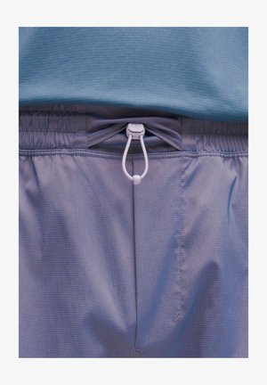 Helllilafarbene Sportshorts mit elastischem Bund und weißem Kordelzug. Der Stoff hat ein dezentes Karomuster und eine glatte Textur.