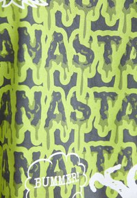 Green and gray fabric featuring a dripping font pattern with the words "BUMMER!" in white. The texture appears smooth with a graphic design.