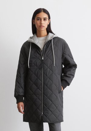 Κουβερτιέ μαύρο μακρύ παλτό με γκρι καπέλο και λευκές κορδόνες, με μπροστινό φερμουάρ και πλαινές τσέπες, κατασκευασμένο από ομαλό, επενδυμένο ύφασμα.