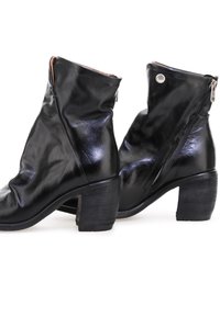 Botas negras de cuero hasta el tobillo con un diseño de arrugado, que incluyen un cierre de cremallera en el lateral y un tacón de madera. Textura suave con un brillo sutil.