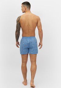 Blauwe zwembroek met patroon en een elastische tailleband, met kleine kleurrijke ontwerpen, gemaakt van lichtgewicht stof en met een ontspannen pasvorm.