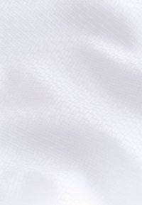 Tessuto bianco con motivo testurizzato, caratterizzato da disegni geometrici delicati. Superficie liscia con qualità morbide e fluide nel drappeggio.