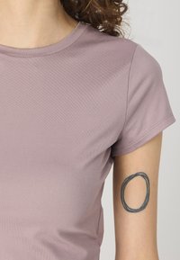 Gai mauve īsā piedurkne T-kreklā ar gludu tekstūru un pieguļošu dizainu. Iespējo apaļu kakla izgriezumu un smalku sānu šuvju noformējumu.