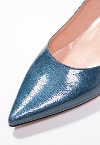 Tyrkysové lakované lodičky s špičatou špičkou a hladkým povrchem, zdobené lesklým finishem a měkkým růžovým podšívkou.