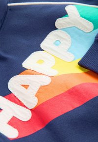 Felpa della marina con la scritta "HAPPY" in lettere bianche e testurizzate, su uno sfondo colorato a strisce arcobaleno nei colori arancione, giallo e blu.