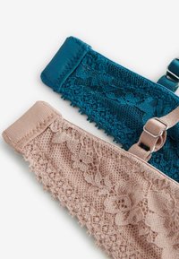 Divas divas: viena tumši zaļa ar mežģīņu apdari un regulējamiem siksniņām, un viena rozā ar ziedu mežģīņu apdari un mīksto elastīgo joslu.