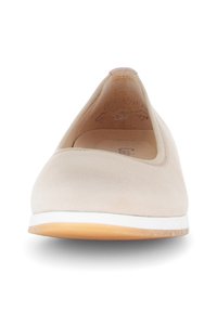 Ballerina beige con una superficie liscia e opaca, punta rotonda e suola in gomma bianca. Presenta linee pulite e accenti minimi.