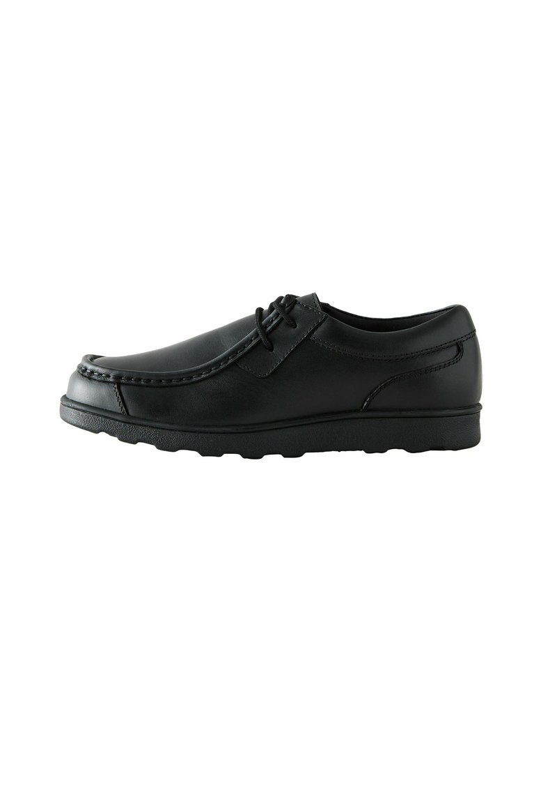 Chaussure en cuir noir avec un bout arrondi, des coutures discrètes et un minimum de détails de lacets. Semelle en caoutchouc flexible. Texture lisse en totalité.