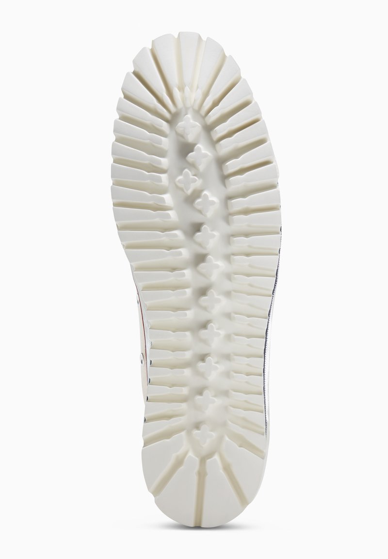Weiße Schuhsohle mit geriffeltem Muster und kreuzförmigen Profilen in der Mitte für besseren Halt auf glatten Flächen.
