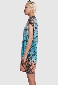 Sukienka tie-dye w niebieskie, czarne i koralowe wzory, z krótkimi rękawami i luźnym krojem, o okrągłym dekolcie i długości do połowy uda.