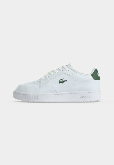 Бял нисък спортен обувка Lacoste с зелен крокодилски лого отстрани и зелен език на петата, бели връзки и детайлно шити подметки.