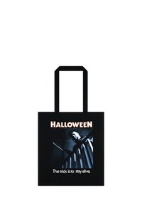 Czarna torba na ramię z graficznym wzorem postaci na schodach, z nożem w dłoni. Tekst głosi "HALLOWEEN" oraz "Sztuczka polega na tym, żeby przeżyć."