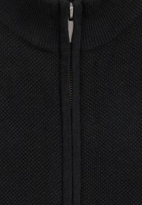 Svart zip-up tröja med strukturerad stickningsmönster, hög krage och metallblixtlås med tygdrag.