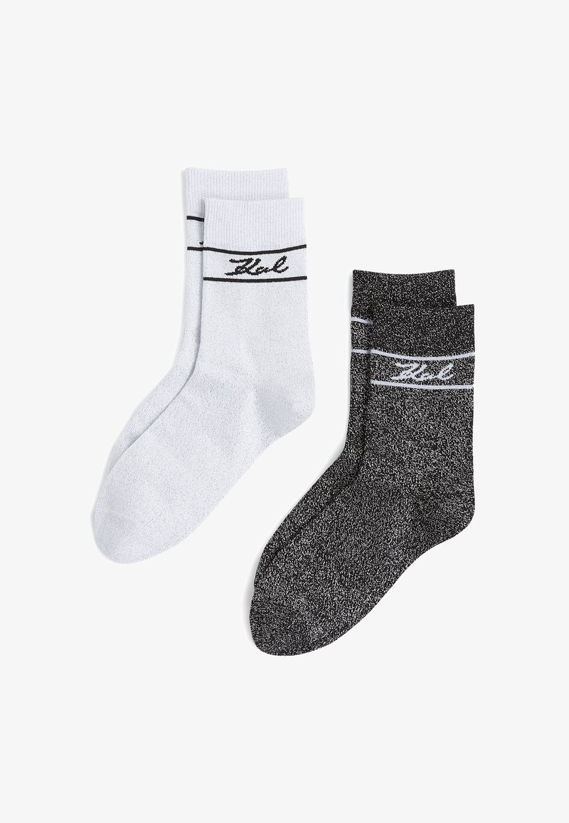 Kaks paari sokke: ühed heledat halli värvi mustade triipudega ja logoga, teised mustad tekstuuriga mustriga ja valgete triipudega üleval.