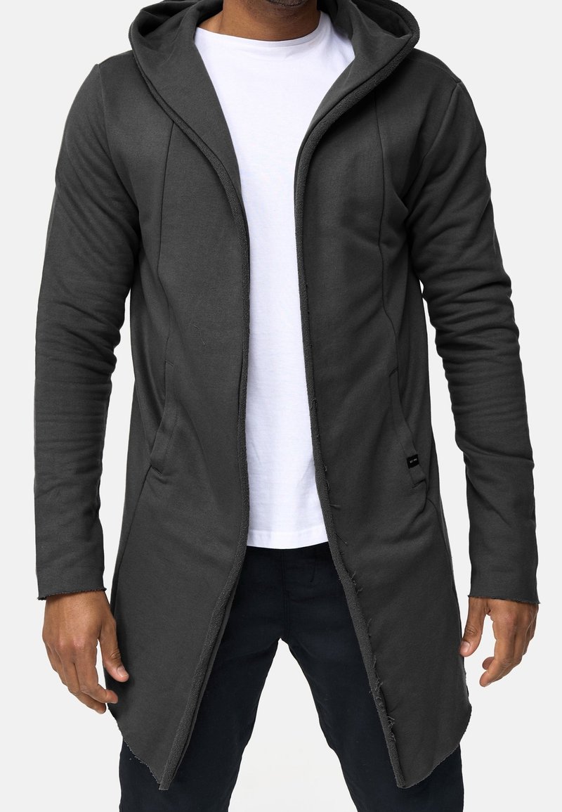 Sudadera con capucha larga de color gris oscuro hecha de material suave, con un corte relajado, silueta estrecha, parte delantera abierta y bolsillos laterales.