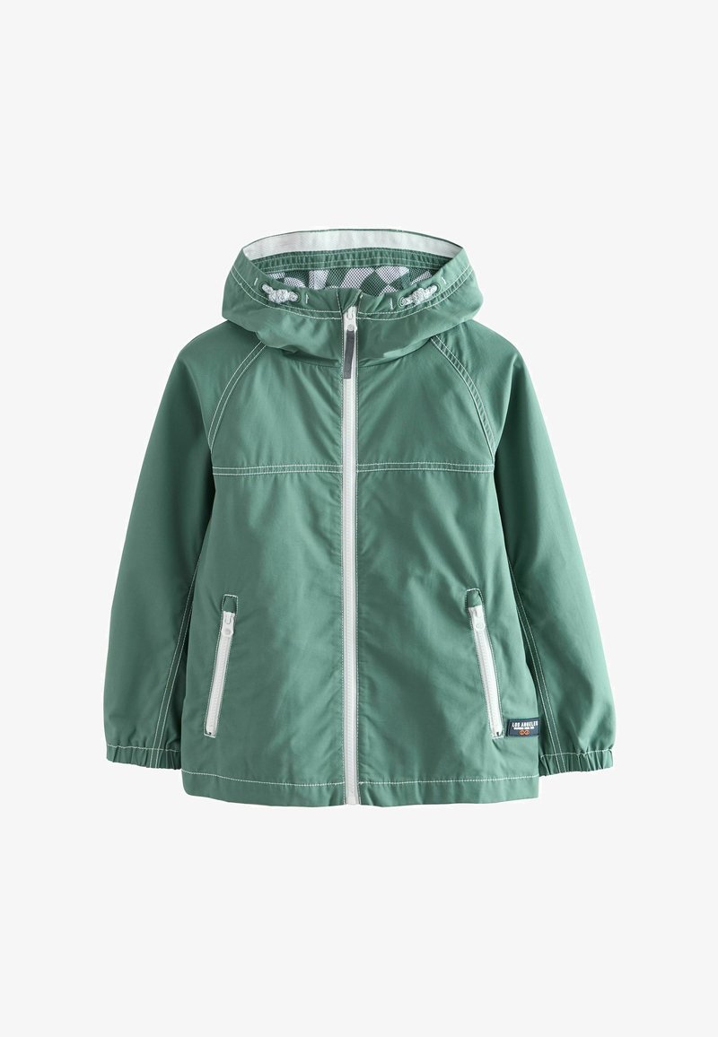 Chaqueta verde con capucha y cremallera blanca, dos bolsillos delanteros con cremallera, puños elásticos y una pequeña etiqueta "Los Angeles" en la parte inferior derecha.